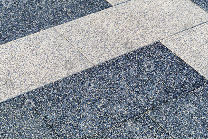 Скачать Покрытие пешеходной дорожки из светло- и темно-серой плитки. Современная текстурированная тротуарная плитка прямоугольной формы. Традиционное мощение двора или дороги фотосток Ozero