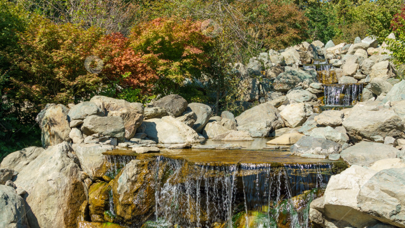 Скачать Тройной водопад разделяется на три потока в японском саду. Общественный ландшафтный парк Краснодара или парк Галицкого, Россия. фотосток Ozero
