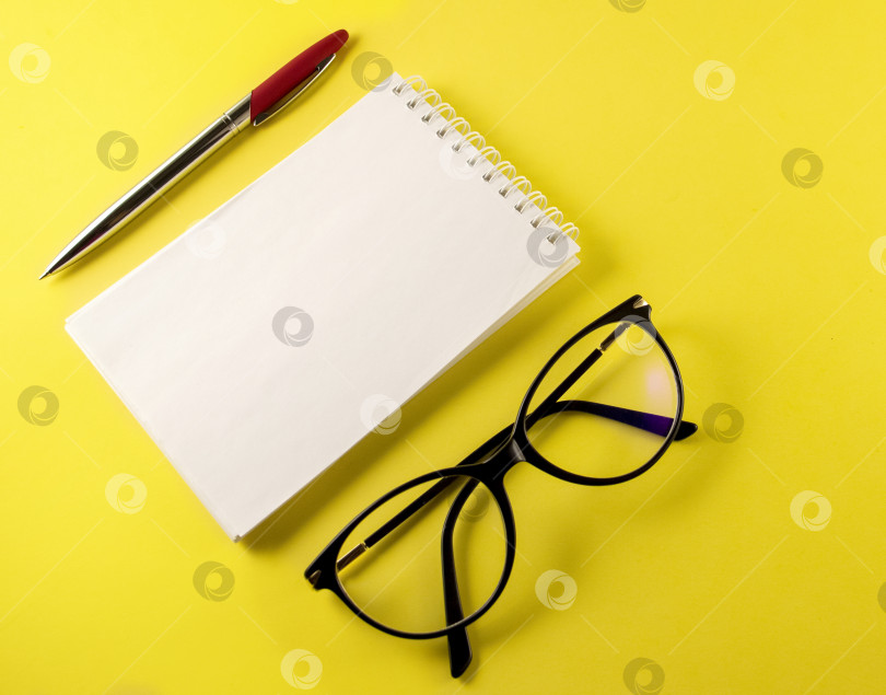 Скачать блокнот, записная книжка, ручка, очки, на желтом фоне, вид сверху, место для копирования фотосток Ozero