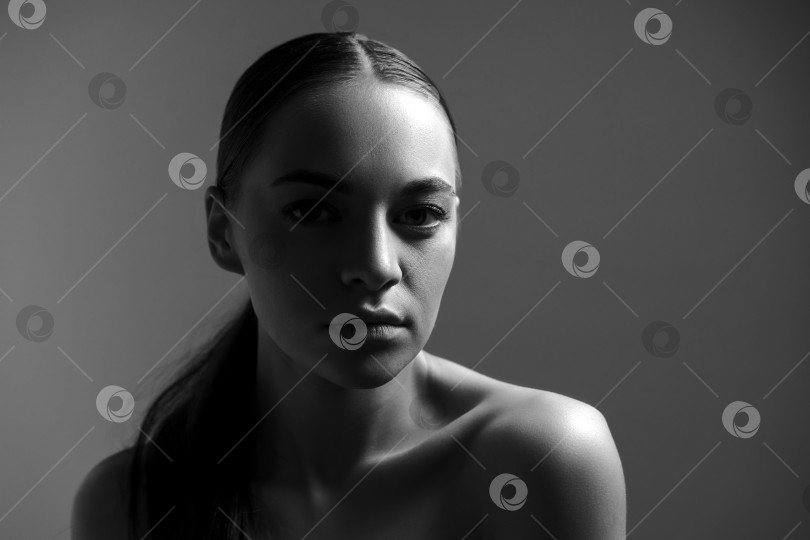 Скачать Студийный портрет симпатичной брюнетки на простом черном фоне. фотосток Ozero