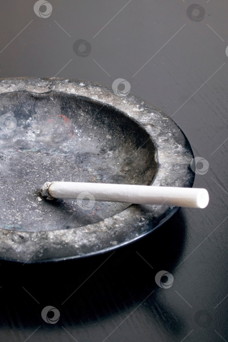 Скачать Зажженная сигарета и пепельница крупным планом фотосток Ozero