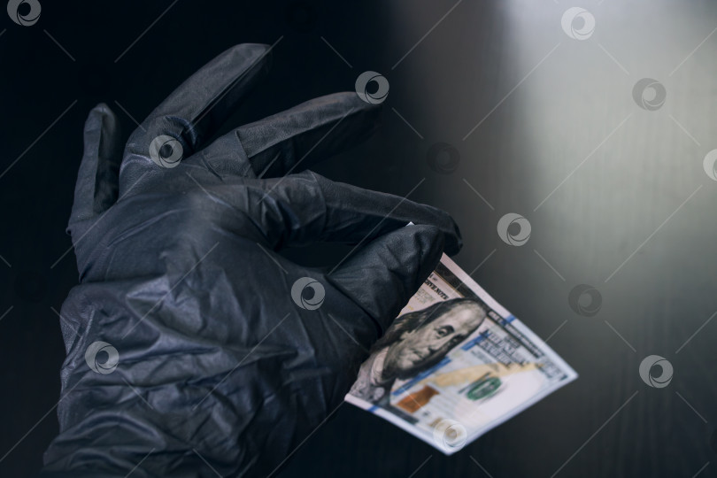 Скачать Рука в перчатке держит доллар фотосток Ozero