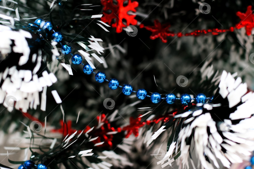 Скачать Праздничные бусы на рождественской елке крупным планом фотосток Ozero