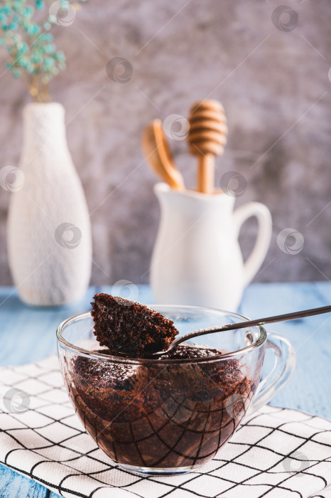 Скачать Шоколадный кекс с сахарной пудрой в кружке на столе вертикальный вид фотосток Ozero