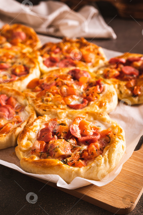 Скачать Свежие пироги для пиццы в горшочках с помидорами, сыром и сосисками на деревянной доске вертикальный вид фотосток Ozero