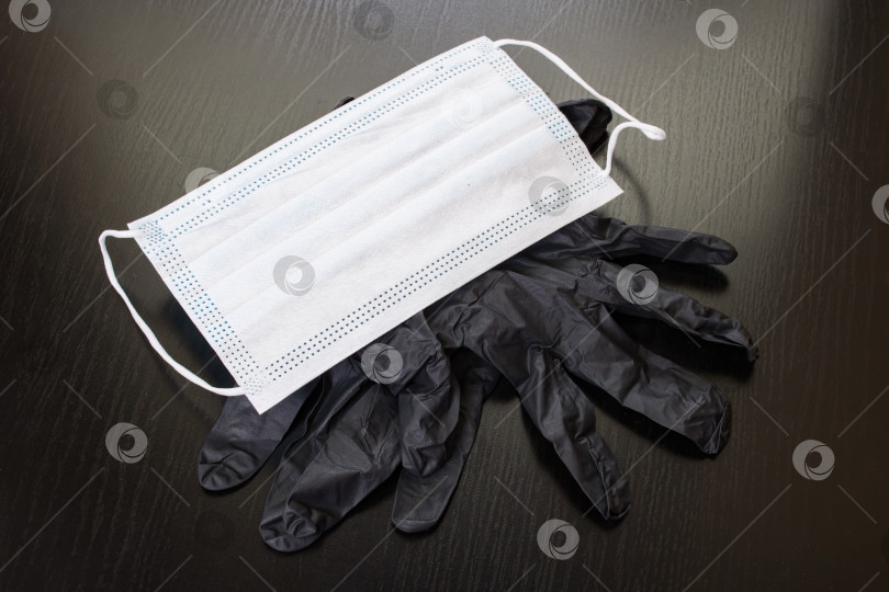 Скачать Черные перчатки и медицинская маска на деревянном фоне фотосток Ozero
