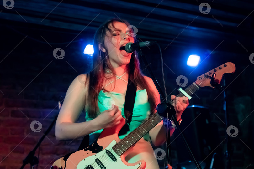 Скачать Беларусь, Минск - 23 июня 2023 года: Девушка с гитарой на сцене фотосток Ozero