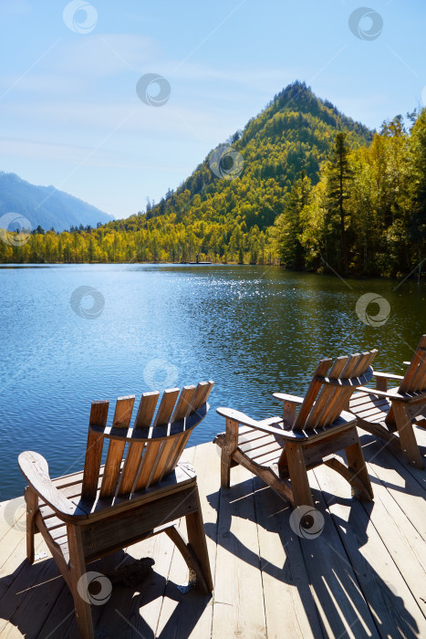 Скачать Красивый осенний пейзаж. Деревянные шезлонги на берегу озера. фотосток Ozero