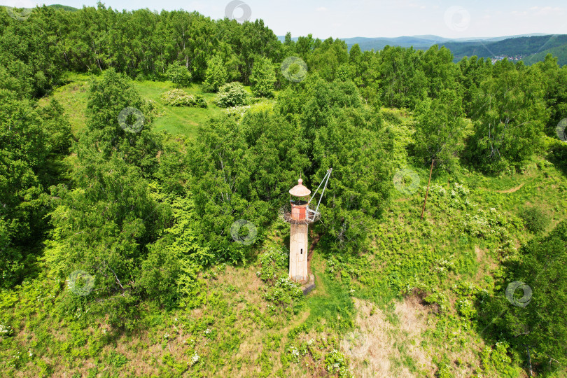 Скачать Старый маяк на горе, покрытой лесом, в летний день. фотосток Ozero