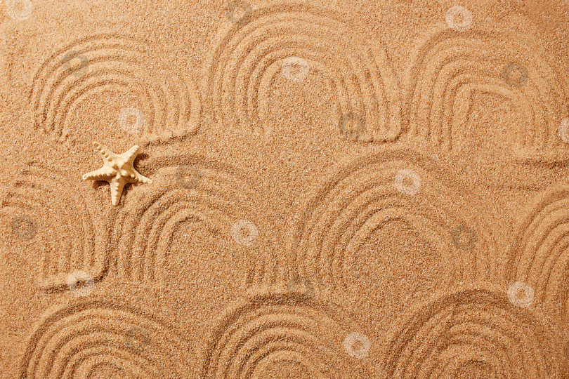 Скачать Узор в виде волн на песке на пляже и морской звезды. фотосток Ozero
