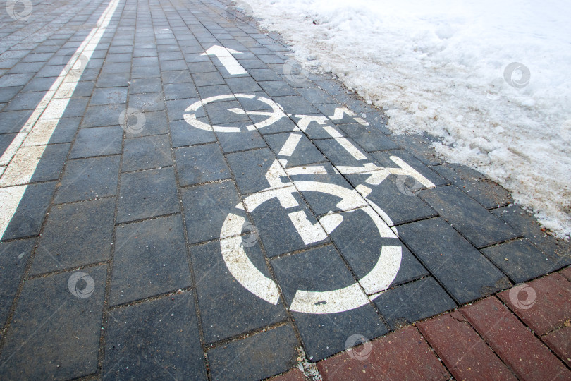 Скачать Знак велосипедной дорожки на снегу крупным планом фотосток Ozero