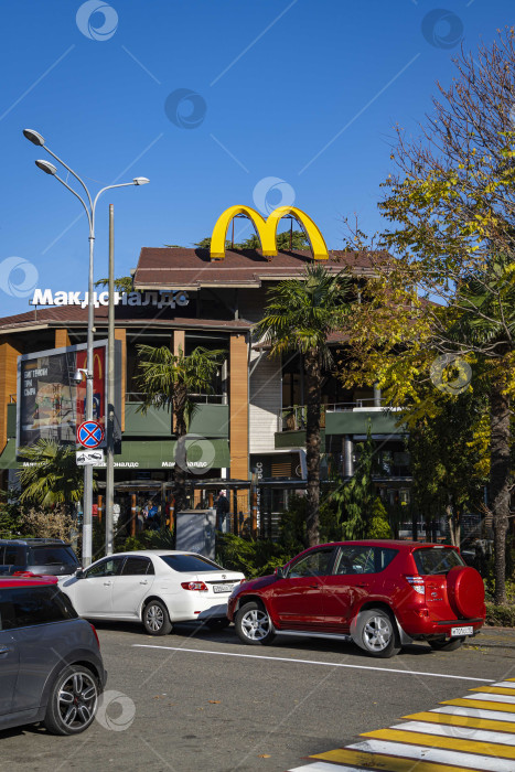 Скачать Символом McDonald's является большая желтая буква "М" на крыше здания. Центр Сочи. Символическая надпись MacDonald на фасаде здания.Солнечный зимний день на юге России. фотосток Ozero