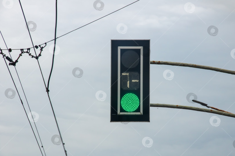 Скачать Зеленый светофор на фоне серого неба фотосток Ozero