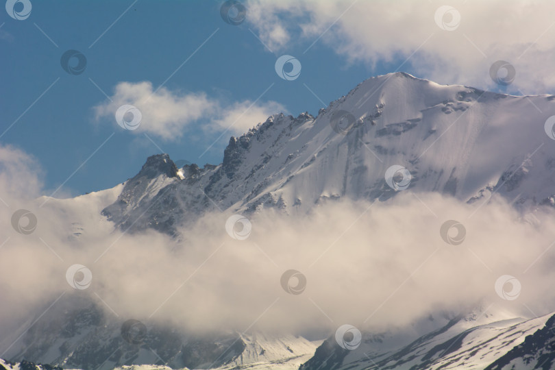 Скачать Заснеженные горные вершины среди облаков, Киргизский хребет, урочище Чонкурчак, страна Кыргызстан. Выборочный фокус фотосток Ozero