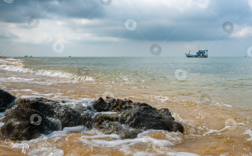 Скачать Рыбацкая лодка под флагом Вьетнама стоит у побережья во время плохой погоды в Южном море фотосток Ozero