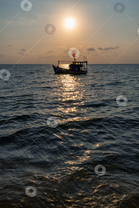 Скачать Рыбацкая лодка под флагом Вьетнама в Южном море на фоне заката фотосток Ozero