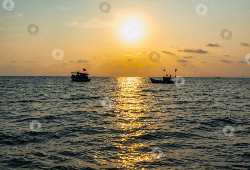 Скачать Рыбацкие лодки под флагом Вьетнама в Южном море на фоне заката фотосток Ozero