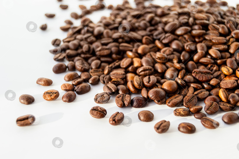 Скачать Жареные зерна кофе рассыпаны на белом фоне фотосток Ozero