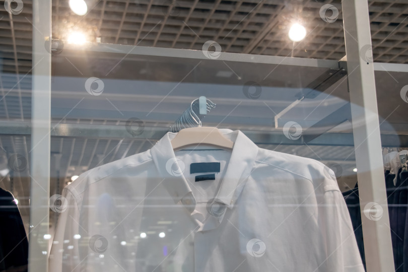 Скачать Белые рубашки на вешалках в магазине крупным планом фотосток Ozero