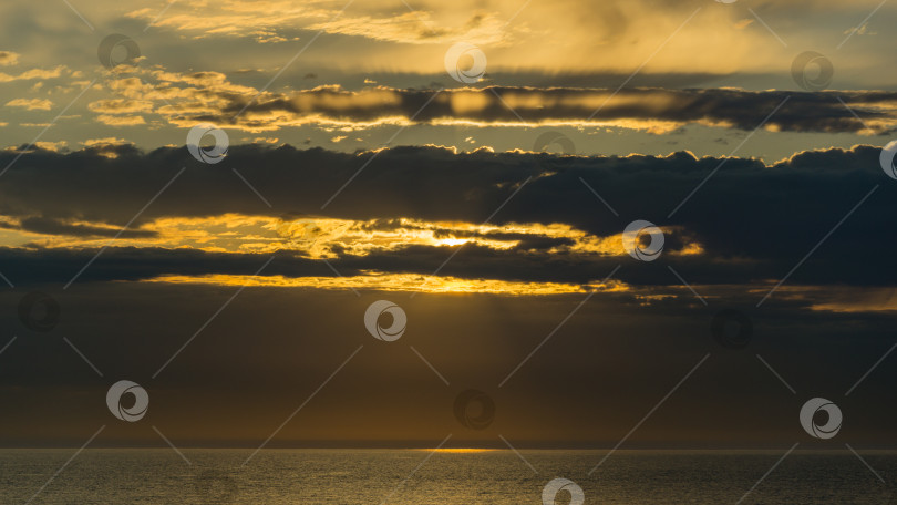 Скачать Красивый морской пейзаж с закатом на горизонте. Сочи, Черноморское побережье юга России. Живописное небо с облаками над золотистой водой Черного моря. Роскошные облака и естественный фон неба фотосток Ozero