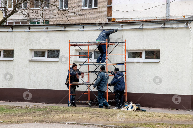 Скачать БЕЛАРУСЬ, НОВОПОЛОЦК - 29 апреля 2020 года: Рабочие красят стену здания фотосток Ozero