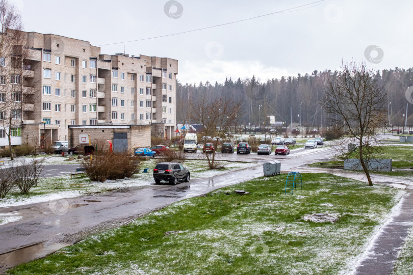 Скачать БЕЛАРУСЬ, НОВОПОЛОЦК - 25 апреля 2020 года: Машины во дворе, зеленая трава и снег фотосток Ozero