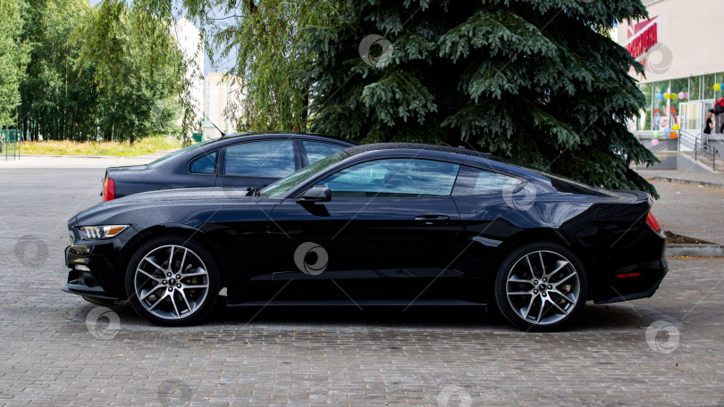 Скачать БЕЛАРУСЬ, НОВОПОЛОЦК - 23 июля 2020 года: Черный автомобиль ford mustang на стоянке фотосток Ozero