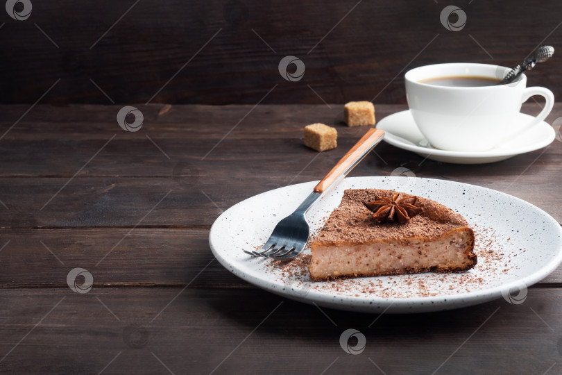 Скачать Кусочек шоколадно-творожной запеканки на тарелке, порционный кусок торта с шоколадом и кофе. Фон из темного дерева в деревенском стиле. место для копирования фотосток Ozero