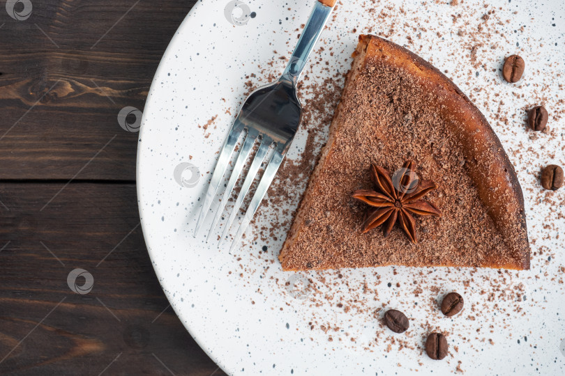 Скачать Кусочек шоколадно-творожной запеканки на тарелке, порционный кусок торта с шоколадом и кофе. Фон из темного дерева в деревенском стиле. место для копирования вида сверху фотосток Ozero