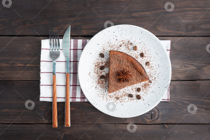 Скачать Кусочек шоколадно-творожной запеканки на тарелке, порционный кусок торта с шоколадом и кофе. Фон из темного дерева в деревенском стиле. место для копирования вида сверху фотосток Ozero