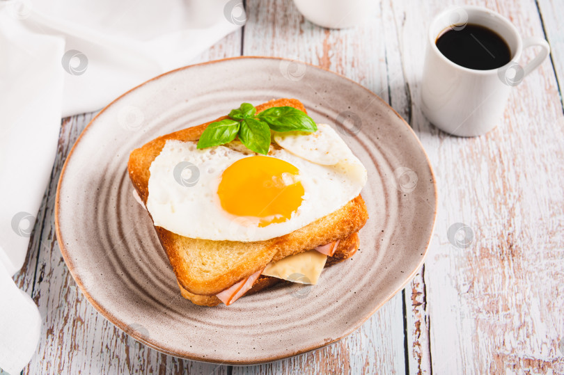 Скачать Французский сэндвич croque madame с горячим завтраком на тарелке на столе фотосток Ozero