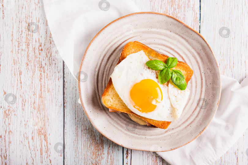 Скачать Крупный план сэндвича croque madame с ветчиной, сыром и яйцом на тарелке на столе вид сверху фотосток Ozero