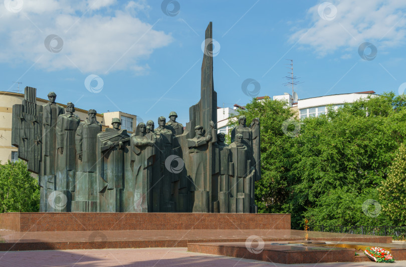 Скачать Вечный огонь на площади Победы в Воронеже. Мемориальный комплекс со скульптурной композицией из 12 фигур на постаменте из красного гранита. Воронеж, Россия - 17 июня 2019 г. фотосток Ozero