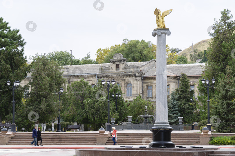 Скачать Колонна с золотым грифоном в центре города Керчь на фоне бывшей женской гимназии. фотосток Ozero