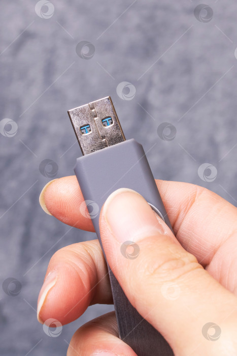 Скачать USB-флешка в руке на сером фоне фотосток Ozero