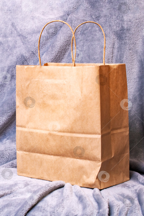 Скачать Бумажный пакет с покупками на сером фоне фотосток Ozero