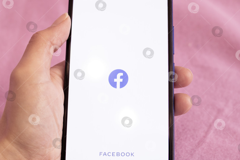 Скачать НОВОПОЛОЦК, БЕЛАРУСЬ - 06 февраля 2021 года: Телефон в руке и логотип facebook на дисплее фотосток Ozero