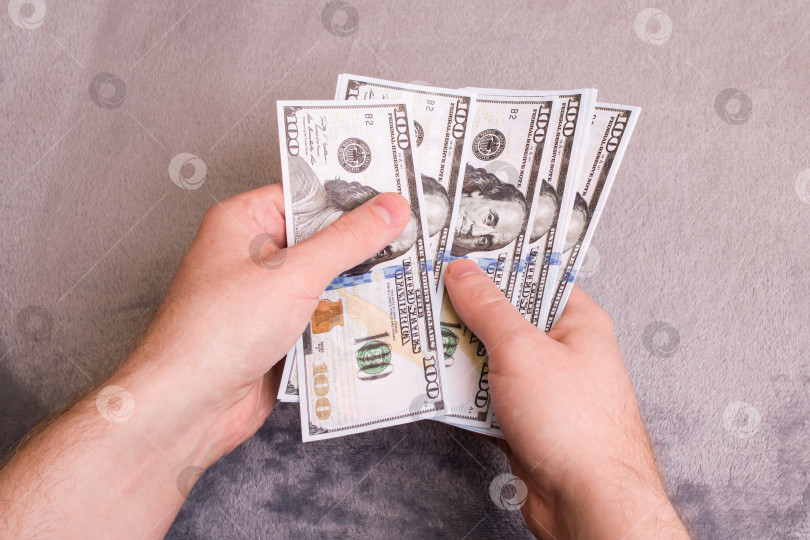 Скачать Руки отсчитывают доллары на сером фоне фотосток Ozero