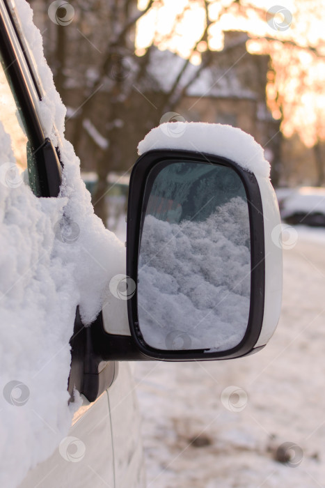 Скачать Снег на боковом стекле и зеркале автомобиля в солнечном свете фотосток Ozero