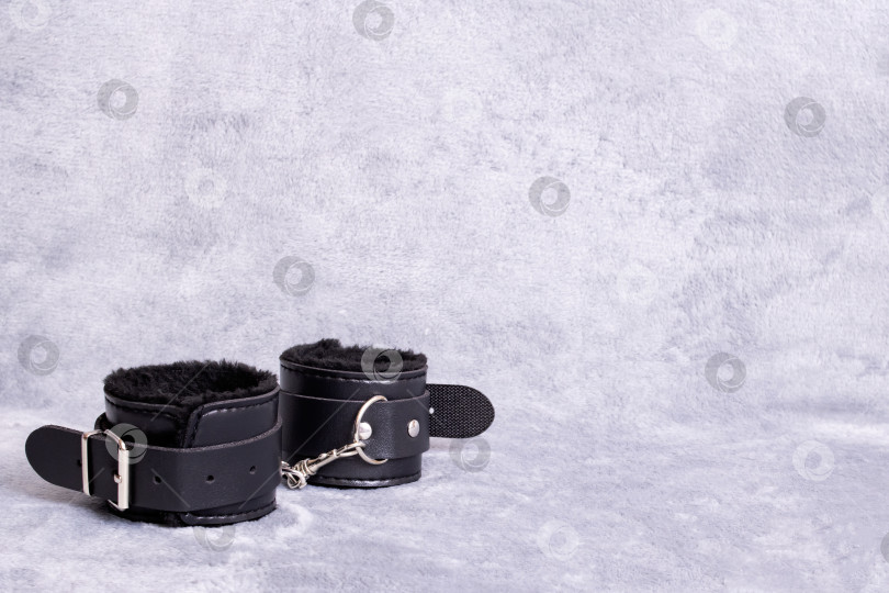 Скачать Черные кожаные наручники на сером фоне фотосток Ozero