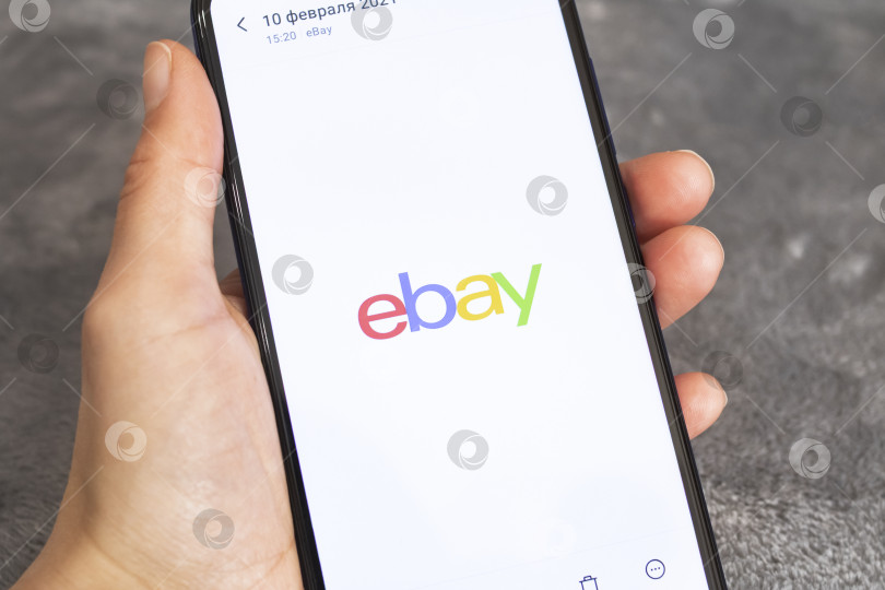 Скачать НОВОПОЛОЦК, БЕЛАРУСЬ - 06 февраля 2021 года: Телефон в руке и логотип ebay на дисплее фотосток Ozero