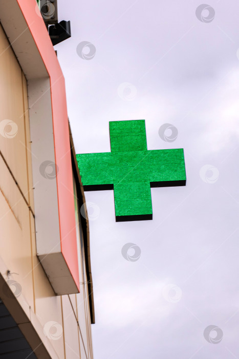 Скачать Вывеска аптеки с зеленым крестом на здании фотосток Ozero