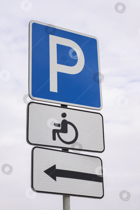 Скачать Дорожный знак парковки для инвалидов на фоне серого неба фотосток Ozero