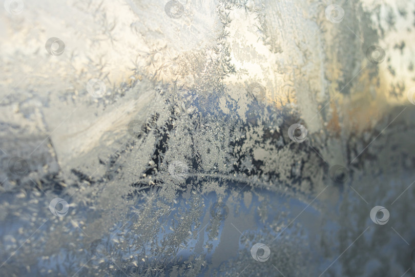 Скачать Морозные узоры на стекле на фоне утреннего солнца фотосток Ozero