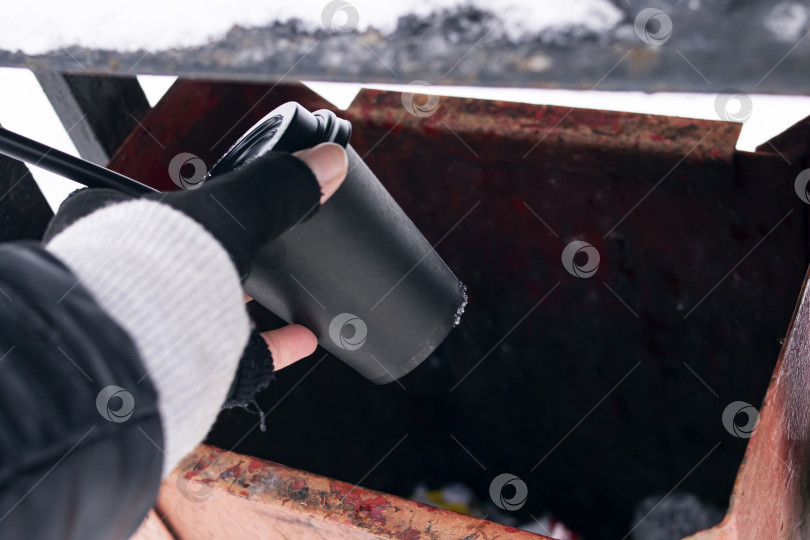 Скачать Рука бросает бумажный стаканчик с кофе в урну фотосток Ozero