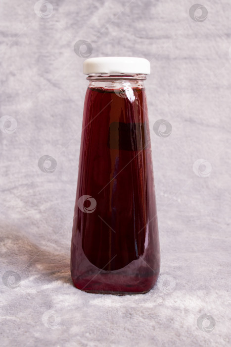 Скачать Красный сок в стеклянной бутылке на сером фоне фотосток Ozero
