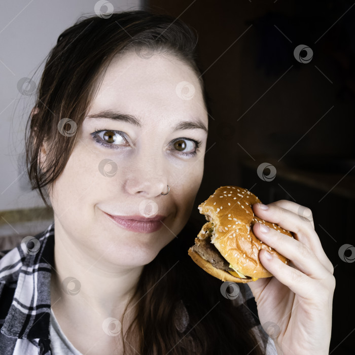 Скачать Улыбающаяся девушка ест гамбургер фотосток Ozero