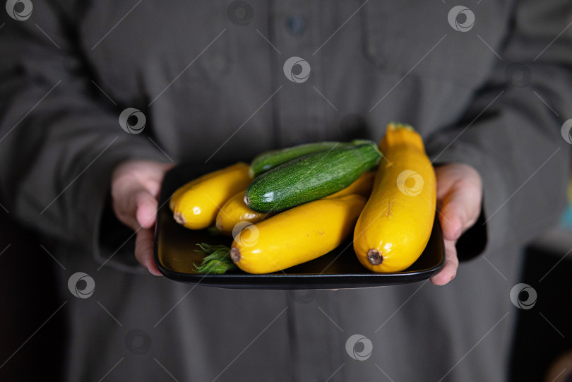 Скачать Руки держат большую тарелку с различными свежими фермерскими овощами. Диета. Баланс. Концепция здорового органического питания фотосток Ozero