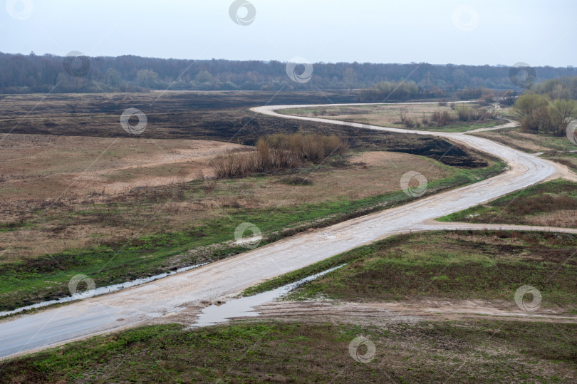 Скачать Весенний пейзаж. Дорога уходит вдаль, вдоль пустых полей. фотосток Ozero