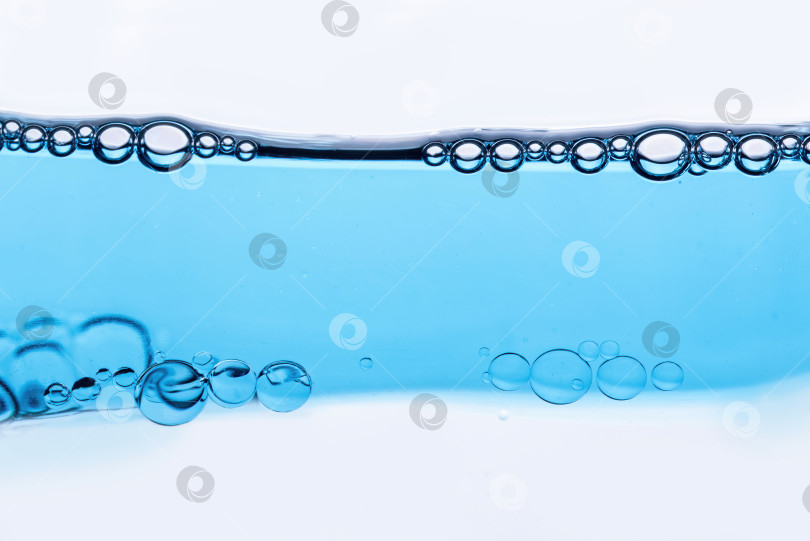 Скачать Крупный план пузырьков в воде, на фоне косметической эссенции, сыворотки в микроскоп фотосток Ozero